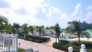 A resort with a pool, palm trees, and a view of the ocean. - Infinity Poolside -  Two story Oceanview 3 Bedrooms / 3 Baths (Bimini)