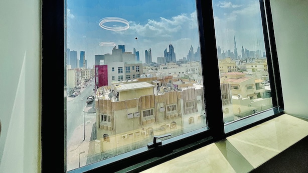 A view from a window overlooking a cityscape with various buildings and a clear sky. - Relaxing, minimal luxurious and safe space vibe in the central area of Dubai.
 (Dubai)