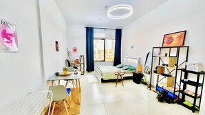 A modern, well-lit room with a bed, a desk, a chair, and a bookshelf. - Relaxing, minimal luxurious and safe space vibe in the central area of Dubai.
 (Dubai)