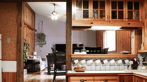 A kitchen with wooden cabinets, a dining area with a table and chairs, and a ceiling fan. - Northstar Lodge - 4000 sq ft + Year-Round Hot Tub (Marquette)