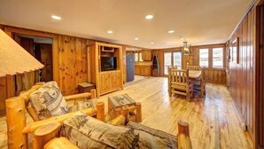 A wooden interior with a dining area, kitchen, and seating. - Pet Friendly Lakefront Cabin
 (Tafton)