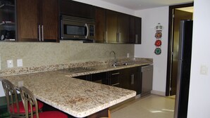 Eine Küche mit Granit-Arbeitsplatten, Edelstahlgeräten und Holzschränken.