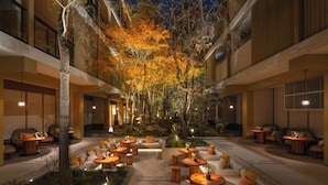 A courtyard with outdoor seating, trees, and a stone pathway. - Six Senses Kyoto (Kyoto)