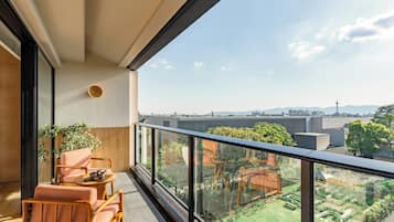 A balcony with a view of a cityscape and a garden.