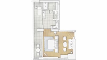 Un plan d’étage d’une chambre d’hôtel comprenant une salle de bain, un coin cuisine, un espace de vie avec un canapé et une table à manger.