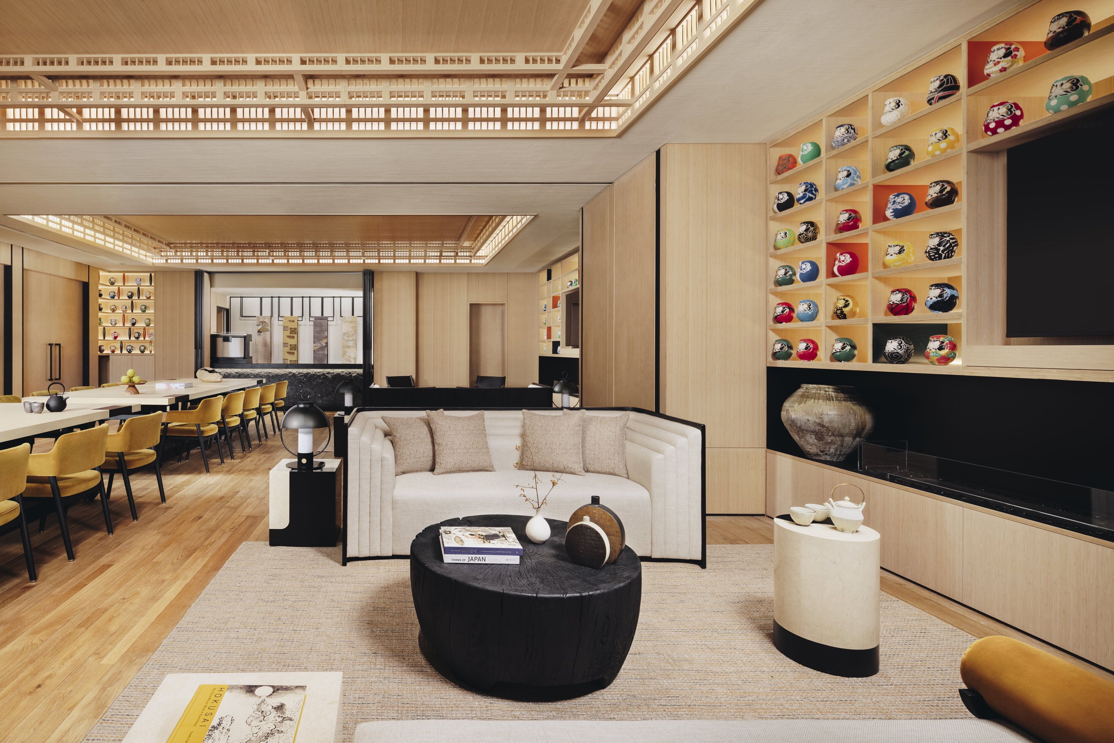 Una sala moderna con sofá, mesa de centro y un expositor de objetos decorativos.