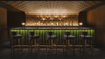 Angolo bar con soffitto decorato, bancone illuminato di verde e cinque sgabelli da bar.