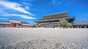 A traditional Japanese building with a large open courtyard and a clear blue sky.