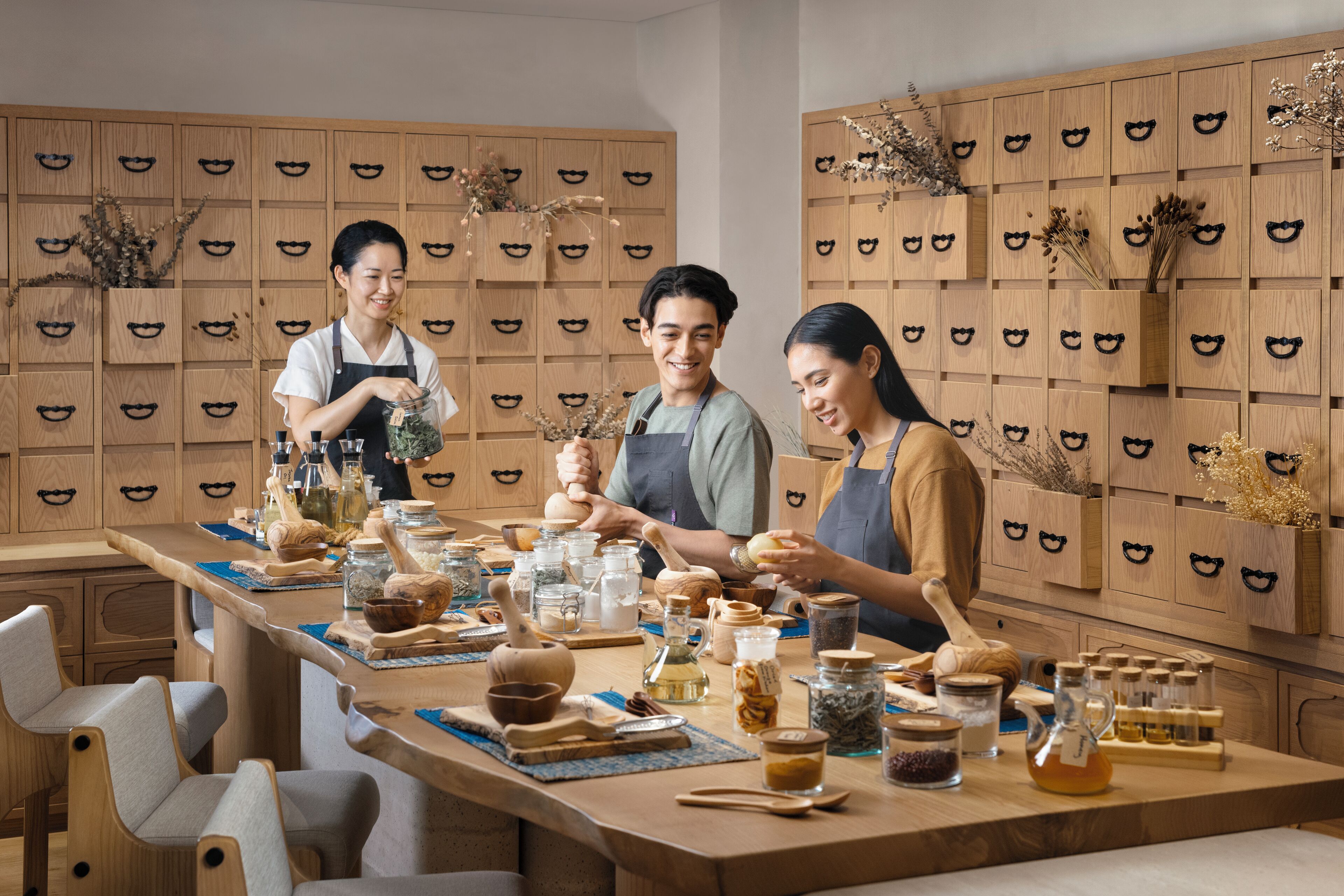 A kitchen with wooden cabinets, a long counter, and various kitchen utensils and ingredients.