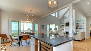 A spacious kitchen with a large island, wooden flooring, and a view to the outside. - Seascapes 714 Ocean Blvd. Charming, Ocean Front, Private Pool (Isle Of Palms)