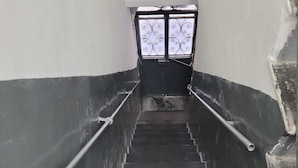 A staircase with black steps and metal handrails, leading to a door with a decorative glass panel. - Incoming Quartieri Spagnoli (Naples)