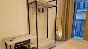 A bedroom with a wooden bed, a desk with a chair, a wardrobe, and a mirror. - Incoming Quartieri Spagnoli (Naples)