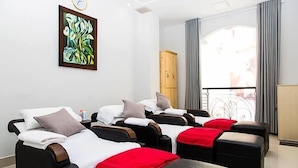 A room with massage chairs, a wooden cabinet, and a large window with curtains. - Diamond Hotel (Ho Chi Minh City)