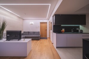 Condo Deluxe | Área de sala de estar | Televisión