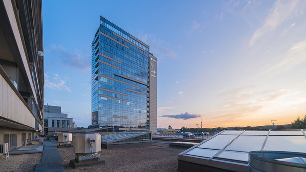 Un edificio moderno con fachada de vidrio, techo plano y cielo despejado.