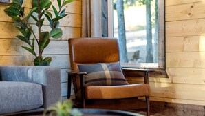 A cozy room with a leather armchair, a grey sofa, and a small table with a plant.