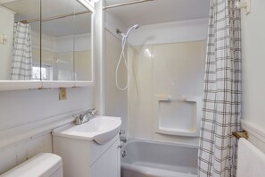 Un baño con lavamanos blanco, inodoro, bañera y ducha.