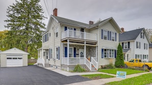 A two-story house with a front porch, a garage, and a driveway. - Pet-Friendly Auburn Apartment w/ Balcony! (Auburn)