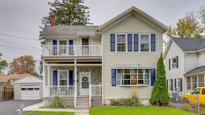 A two-story house with a front porch, a garage, and a small yard. - Pet-Friendly Auburn Apartment w/ Balcony! (Auburn)