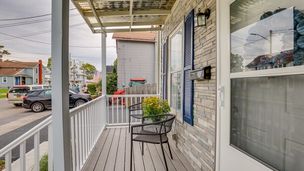 A covered porch with a railing, a window with shutters, and a chair. - Central Auburn Apartment w/ Porch: Pets Welcome! (Auburn)