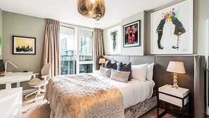 Ein modernes Hotelzimmer mit einem großen Bett, einem Schreibtisch und Blick auf die Stadt.