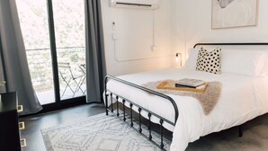 A modern bedroom with a bed, a window, and an air conditioning unit. - The Mylo – Dreamy Stay in Walkable ATL + Rooftop (Atlanta)