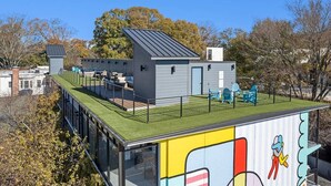 A modern building with a green roof, a small attached structure, and outdoor seating. - La Penelope – Walk to Ponce City Market + Rooftop (Atlanta)