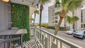A balcony with a view of the beach, a table, chairs, and a railing. - Amazing sunrises & beach views from private balcony & steps from the sand!! (Jacksonville Beach)
