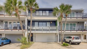 A two-story residential building with a balcony, a garage, and two cars parked in front. - Amazing sunrises & beach views from private balcony & steps from the sand!! (Jacksonville Beach)