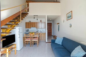 A modern apartment with a staircase, a dining area, a kitchen, and a living room with a sofa. - CO.RI. Appartamenti 5, Menaggio, Italy (Menaggio)