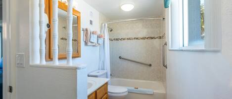 A bathroom with a toilet, sink, and bathtub.