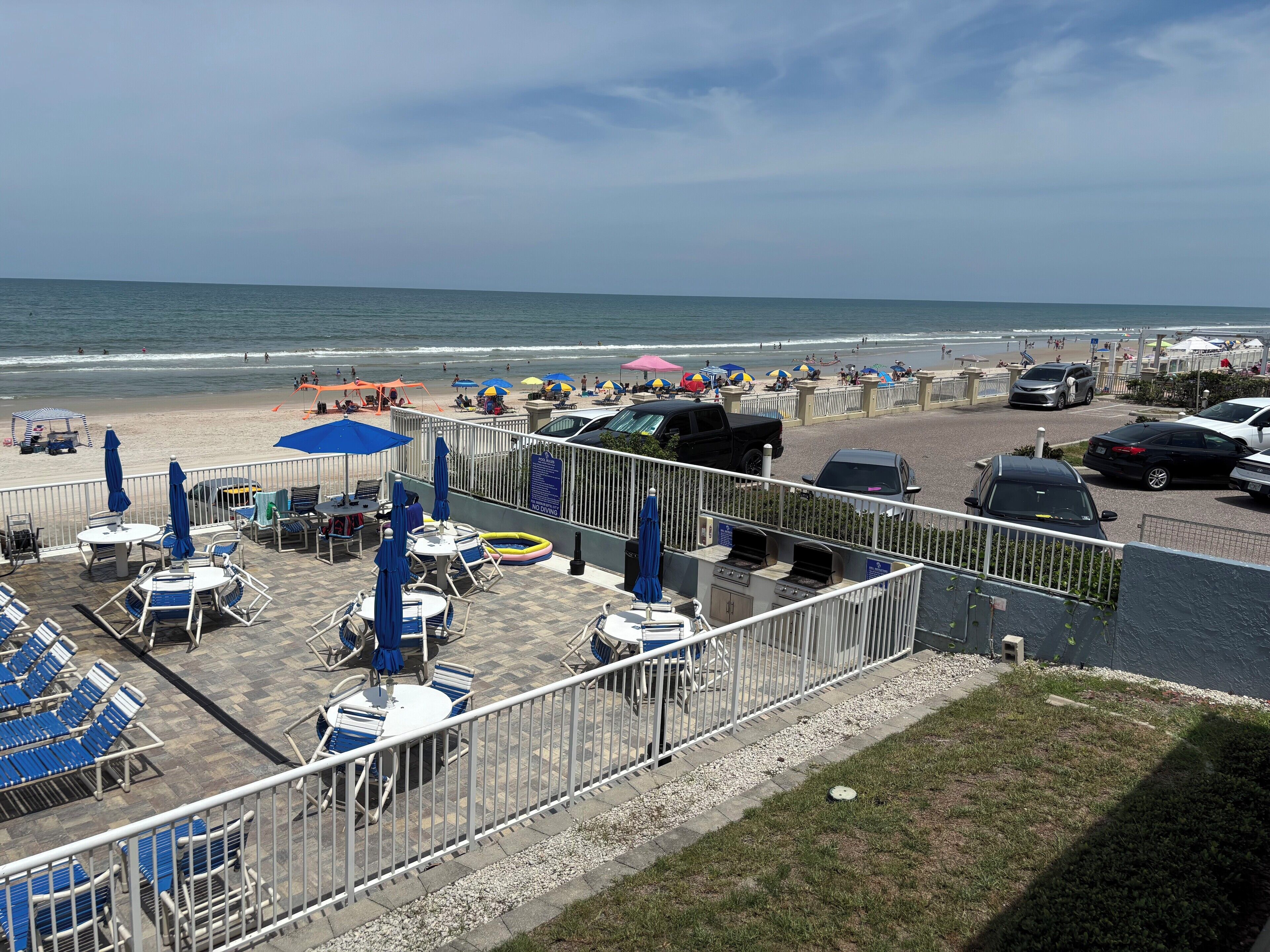 Eine Terrasse direkt am Strand mit Sitzgelegenheiten und Sonnenschirmen mit Blick auf den Ozean.