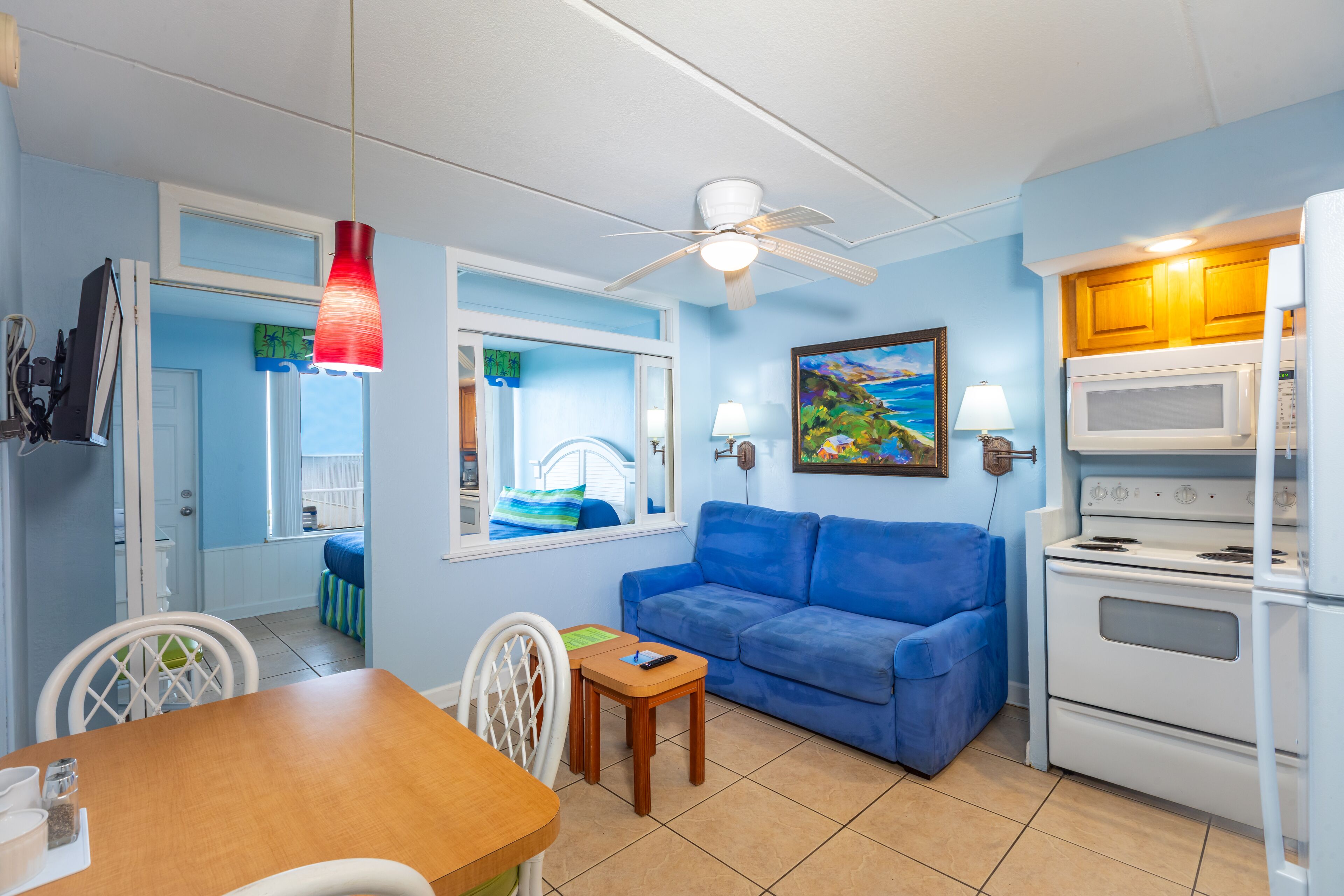 A compact living space with a kitchenette, a dining area, and a sofa.