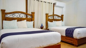A double room with two wooden beds, white bedding, and a small vase on the nightstand. - Cozy Cabin with Terrace and Panoramic View- Access to Pool (Ejido El Porvenir (Guadalupe))