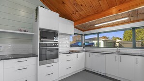 A modern kitchen with white cabinetry, a built-in oven, and a dishwasher.