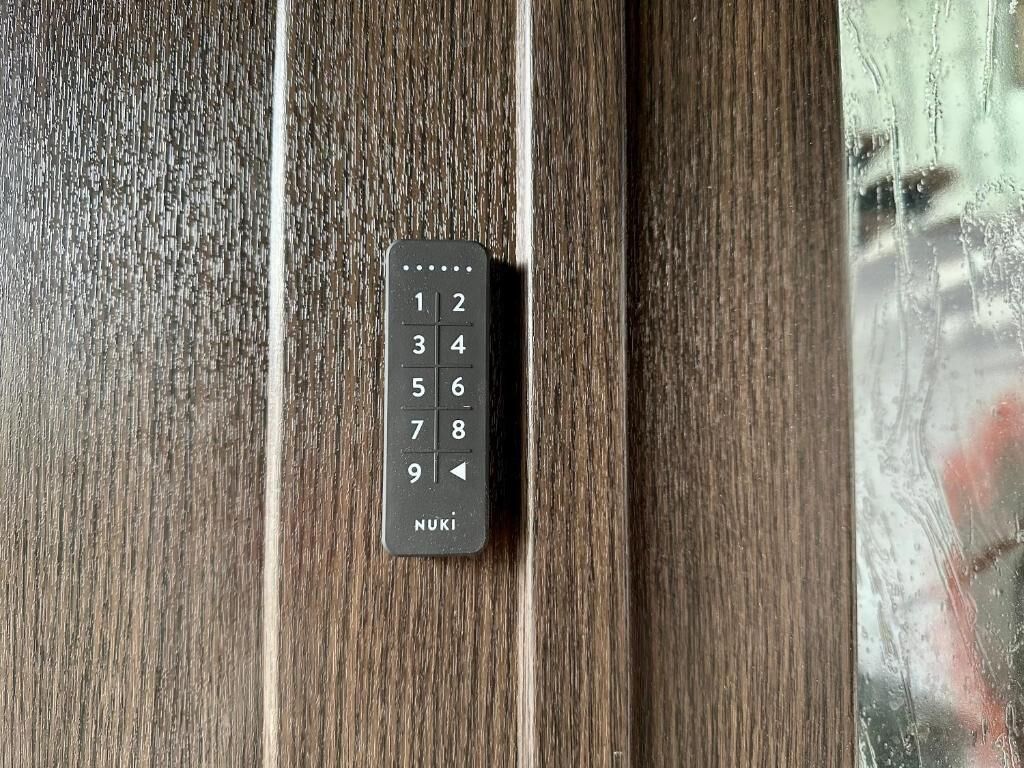 Ein schwarzes Zahlenfeld an einer Holztür.