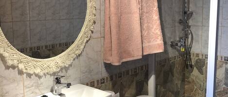 A bathroom with a sink, toilet, and shower.