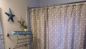 Un baño con inodoro, lavamanos y cortina de ducha.