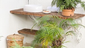A bathroom with a white sink, a mirror, and various plants. - Peixe Crew Rua das Pedras (Búzios)