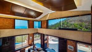 A modern multi-level interior with large windows offering views of a mountainous landscape. - Exclusive Master Suite - Casa Samo (Puerto Vallarta)