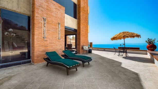 A terrace with two lounge chairs, a table, and a large umbrella. - Exclusive Master Suite - Casa Samo (Puerto Vallarta)
