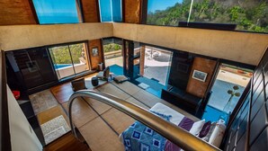 A modern interior with a balcony, a dining area, and a view of the outdoors. - Exclusive Master Suite - Casa Samo (Puerto Vallarta)