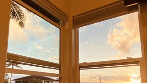 A corner room with two windows overlooking a residential area during sunset. - Brand New Studio with Sunset View (Haleiwa)