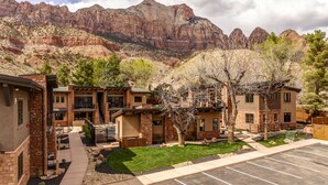 Zona residencial con casas modernas, un estacionamiento y montañas al fondo.