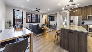 Una cocina moderna con una isla central, armarios de madera y electrodomésticos de acero inoxidable.