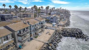 Une zone résidentielle côtière, avec des maisons, une côte rocheuse et une vue dégagée sur l’océan.
