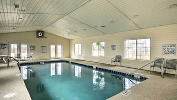 An indoor swimming pool with clear signage, including 'No Diving' and 'Shallow Water No Diving' warnings.