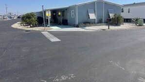 A single-story building with a flat roof, a covered entrance, and a small patio area with plants. - Fishing haven with dock, soaking pool, and quick fishing destinations. (Saint James City)