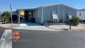 Une maison de plain-pied avec un porche couvert, un garage et un petit jardin devant.