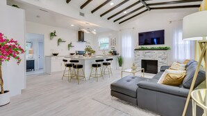 Una cocina moderna con una isla central, taburetes de bar y una chimenea.